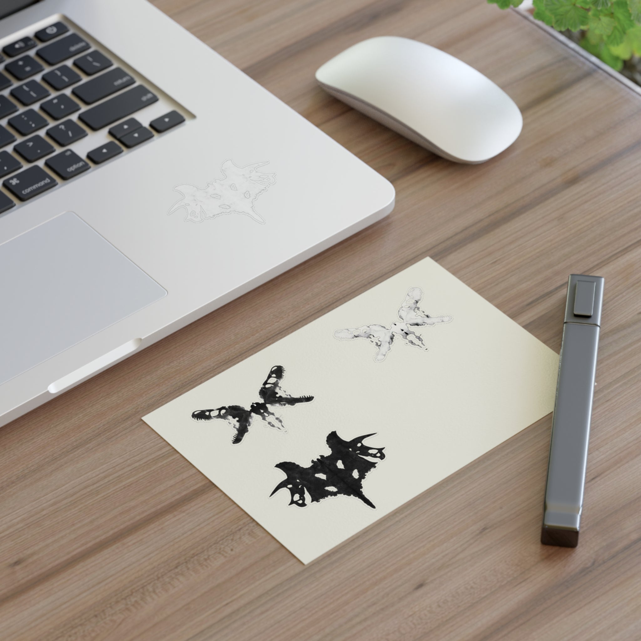 Black and white Rorschach style stickers on a desk next to a computer