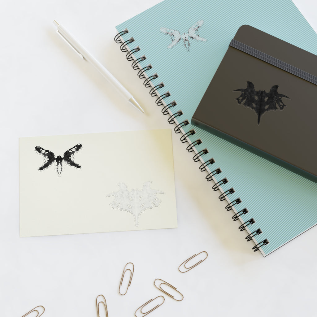 Black and white Rorschach style stickers placed on notebooks