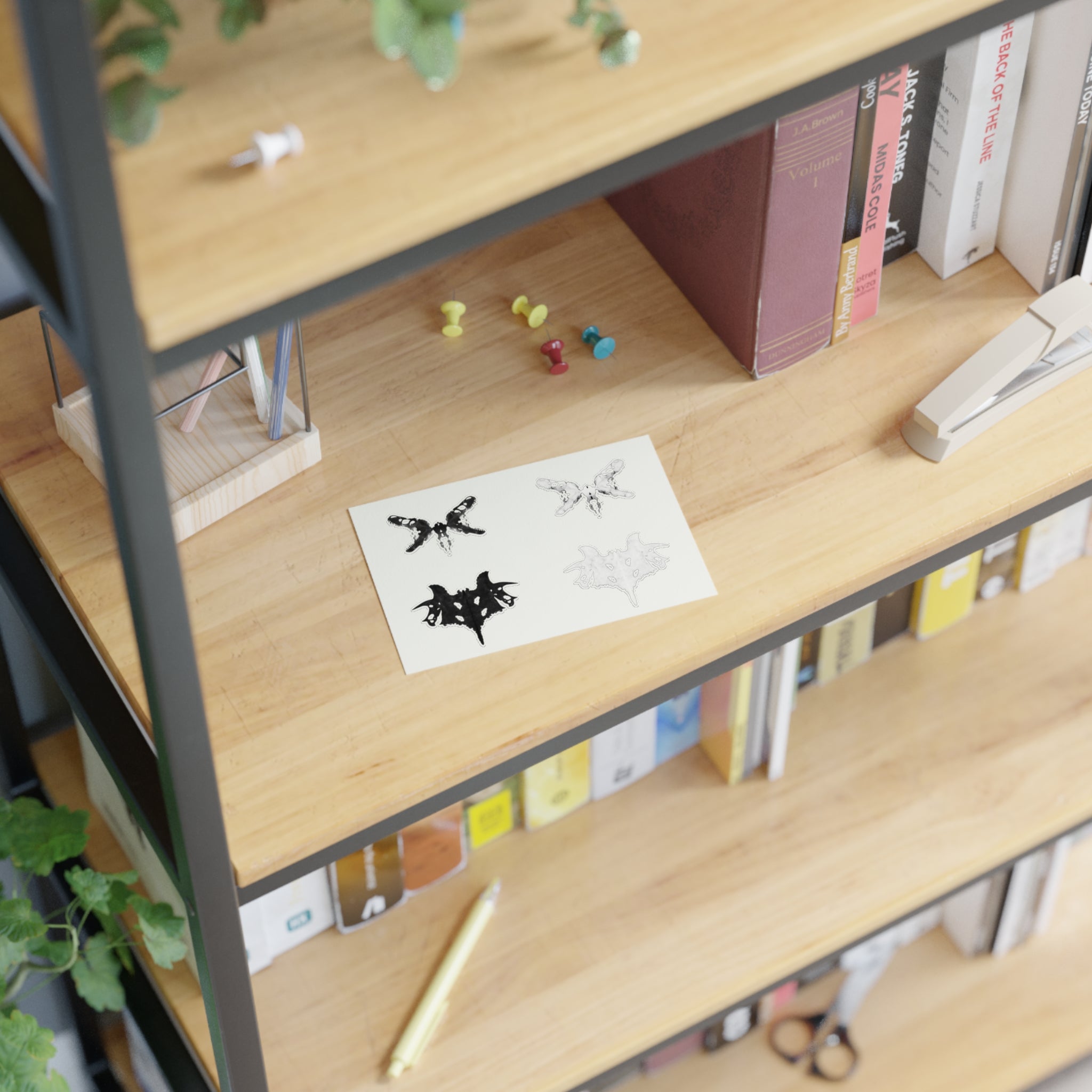 Black and white Rorschach style stickers on a book shelf
